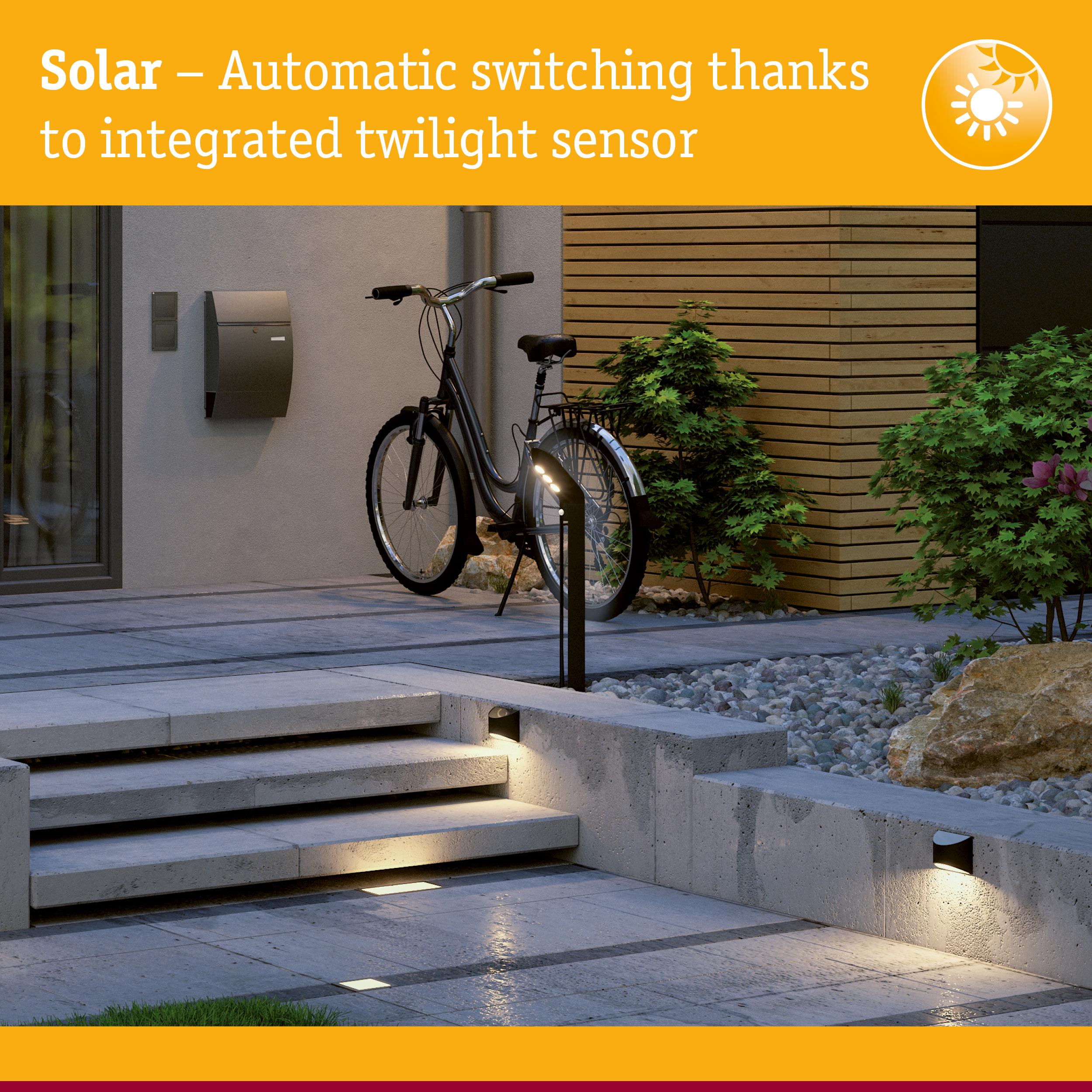 Modern outdoor lighting with integrated twilight sensor illuminating concrete steps and pathway at dusk