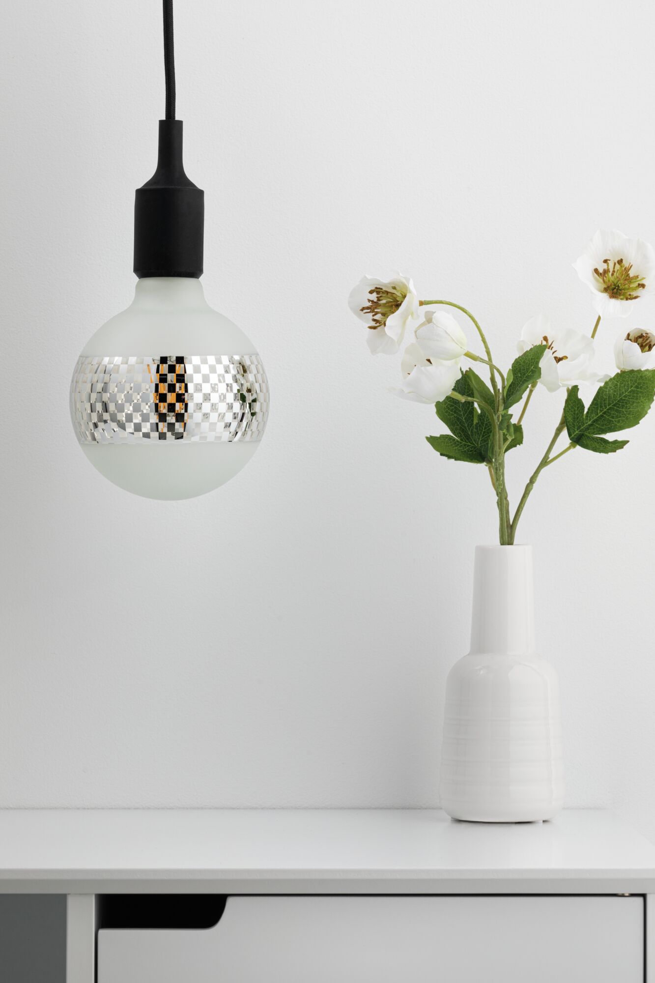Modern pendant light with matte white glass bulb and silver checkered pattern, black cable, home lighting