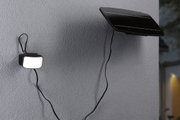 Panneau solaire noir avec lumière LED extérieure connectée sur mur gris pour éclairage économique