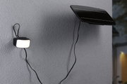 Panneau solaire noir avec lumière LED extérieure connectée sur mur gris pour éclairage économique