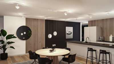 Moderne Wohnküche mit runder Holz-Tischplatte, schwarzen Stühlen und weißen Pendelleuchten an der Decke