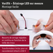 Mains assemblant un spot LED de plafond blanc avec ressorts réglables et connexion câble d'alimentation