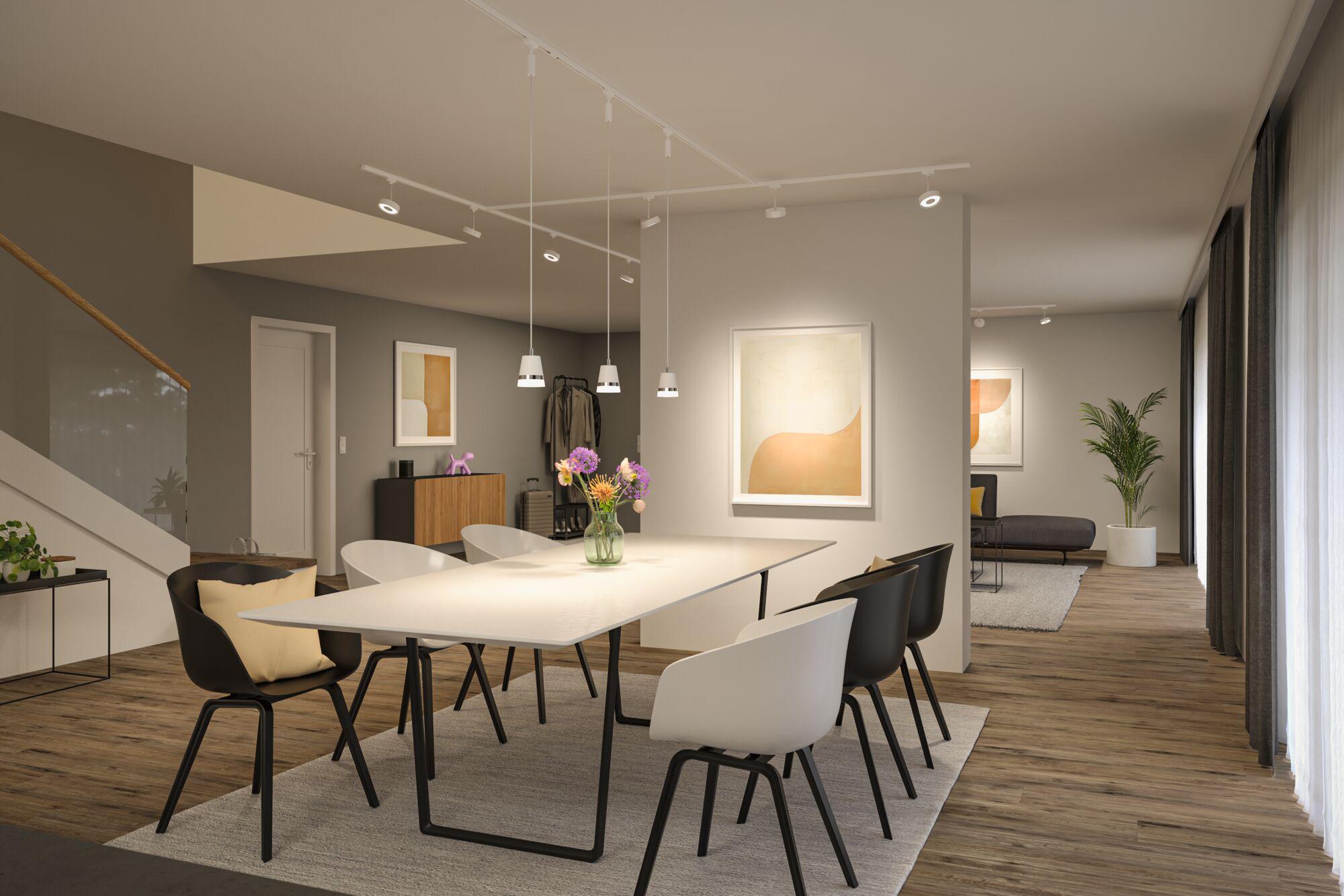 Moderner Essbereich mit weißem Tisch, schwarzen und weißen Stühlen auf Holzfußboden und LED-Deckenleuchten.
