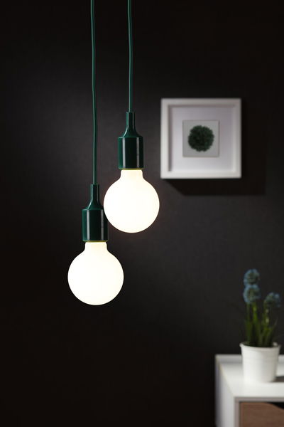 Twee hangende LED-lampen met groene snoeren tegen donkere muur, moderne woonverlichting.