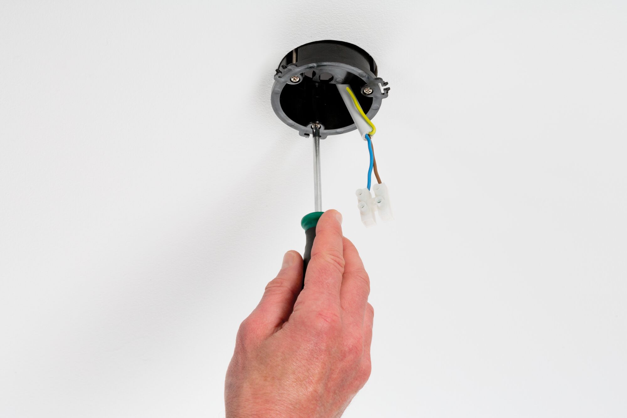 Hand installing black ceiling junction box with screwdriver and visible wires for LED lighting setup