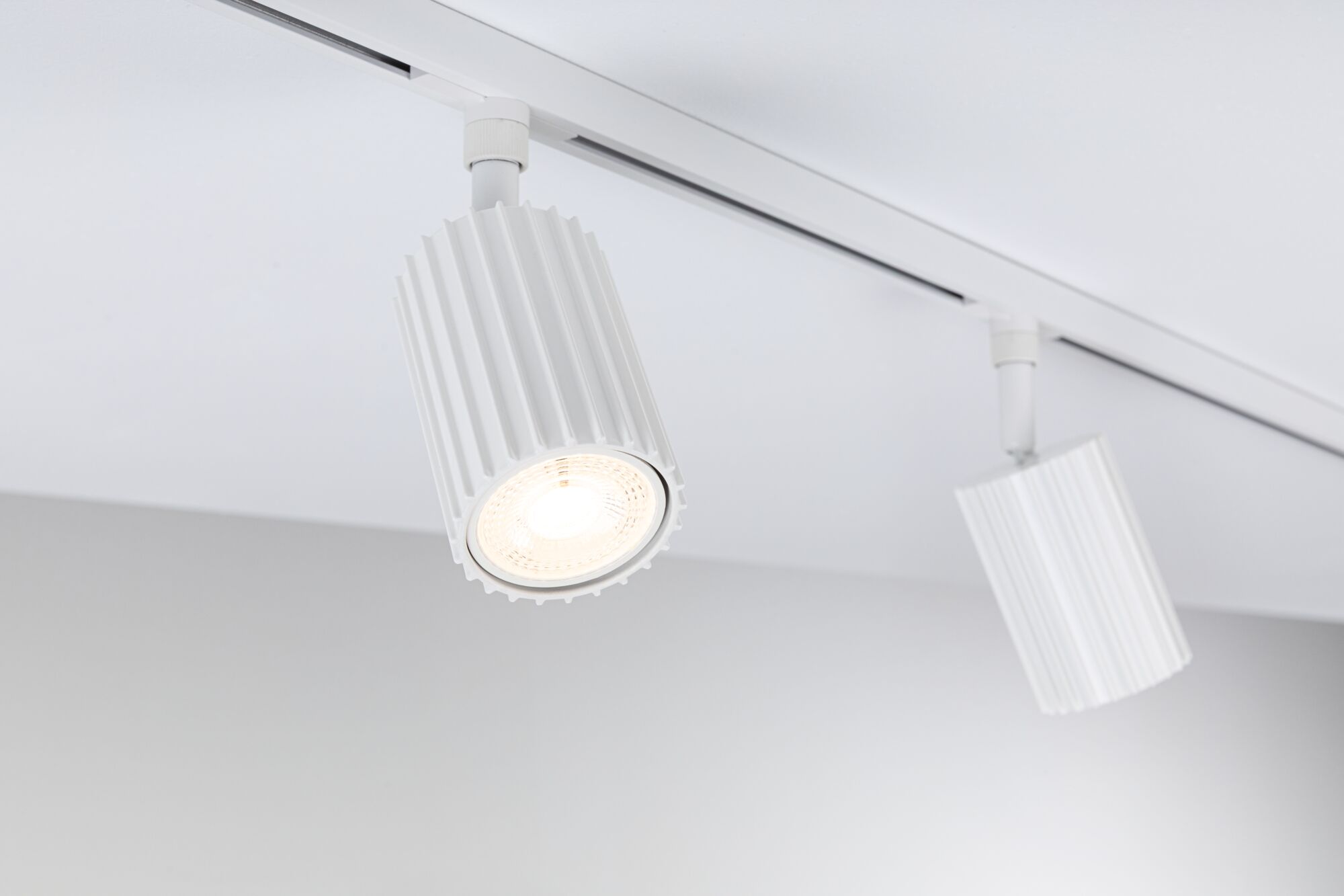 Hvid LED-spot i aluminium med ribbet design på skinnesystem til moderne rumlys