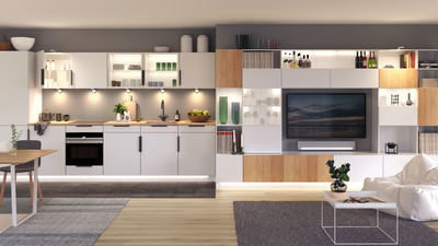 Cuisine blanche moderne avec plan de travail en bois et éclairage LED intégré dans un salon ouvert avec TV.