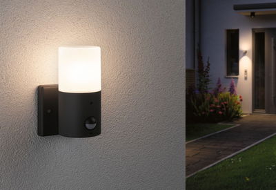 Moderne Außenwandleuchte aus schwarzem Metall mit weißem Glas und Bewegungsmelder für Gartenbeleuchtung.