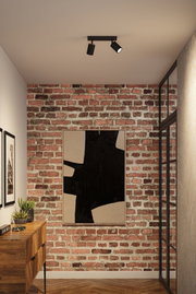 Schwarze Deckenstrahler aus Metall mit zwei verstellbaren Spots in modernem Flur mit Backsteinwand