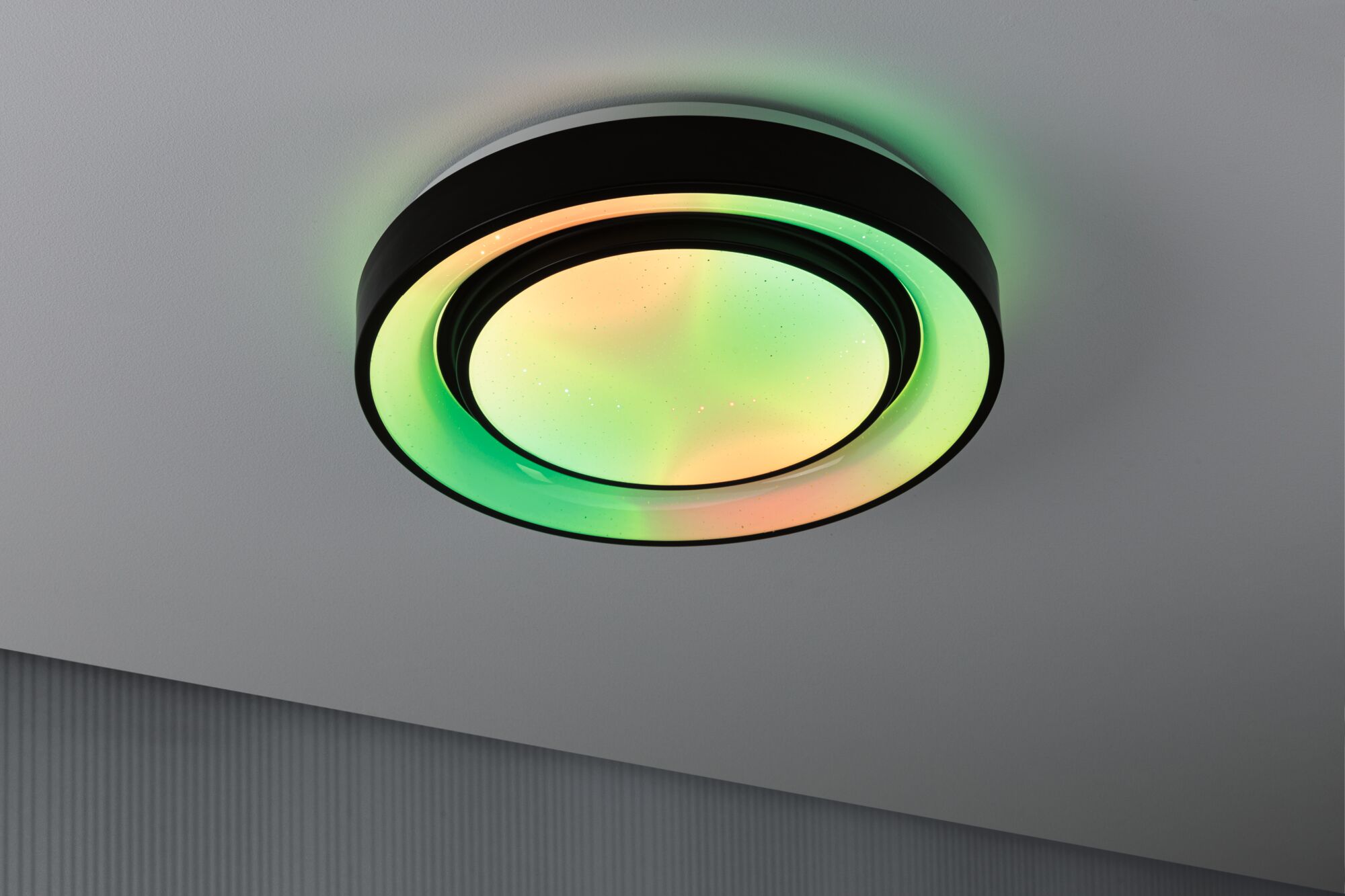 Round ceiling light with black frame and multicolored LED illumination for modern interiors.