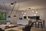Moderne open woonkeuken met zwarte hanglampen en minimalistische witte keukenkasten
