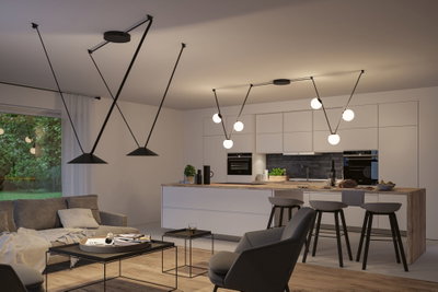 Moderne offene Wohnküche mit schwarzen Pendelleuchten und minimalistischer weißer Küchenzeile