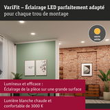 Salon avec éclairage LED blanc chaud encastré, mur vert et mur en briques rouges, ambiance chaleureuse