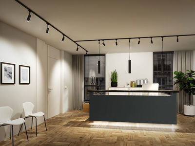 Modern office with black reception desk, wooden parquet floor, and black LED track lights on ceiling