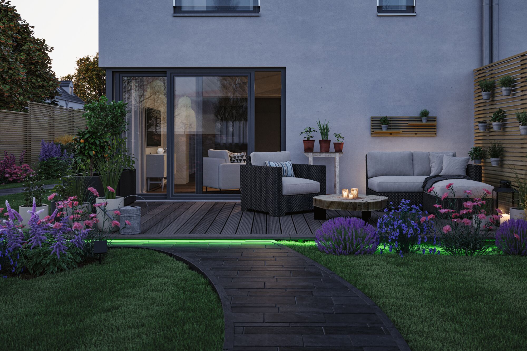 Moderner Garten mit grauem Lounge-Set und LED-Beleuchtung am Weg, umgeben von bunten Blumen und Pflanzen.