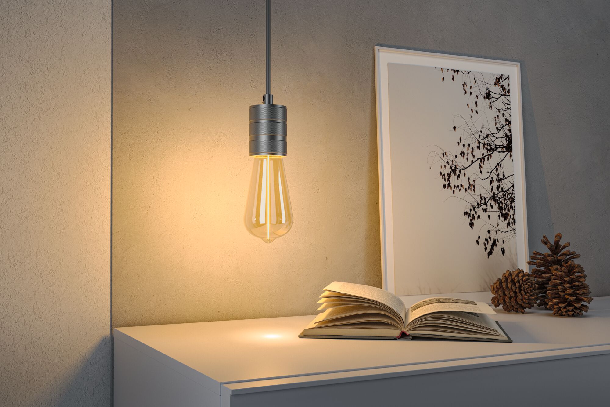 Hängende LED-Glühbirne mit warmweißem Licht über weißem Sideboard mit Buch und Deko.