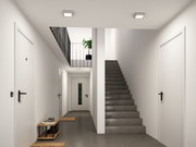 Couloir moderne avec sol gris, portes blanches et deux plafonniers carrés en métal et plastique