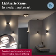 Moderne matte zwarte wand- en plafondlampen in elegante badkamer met grijze muren en minimalistisch design