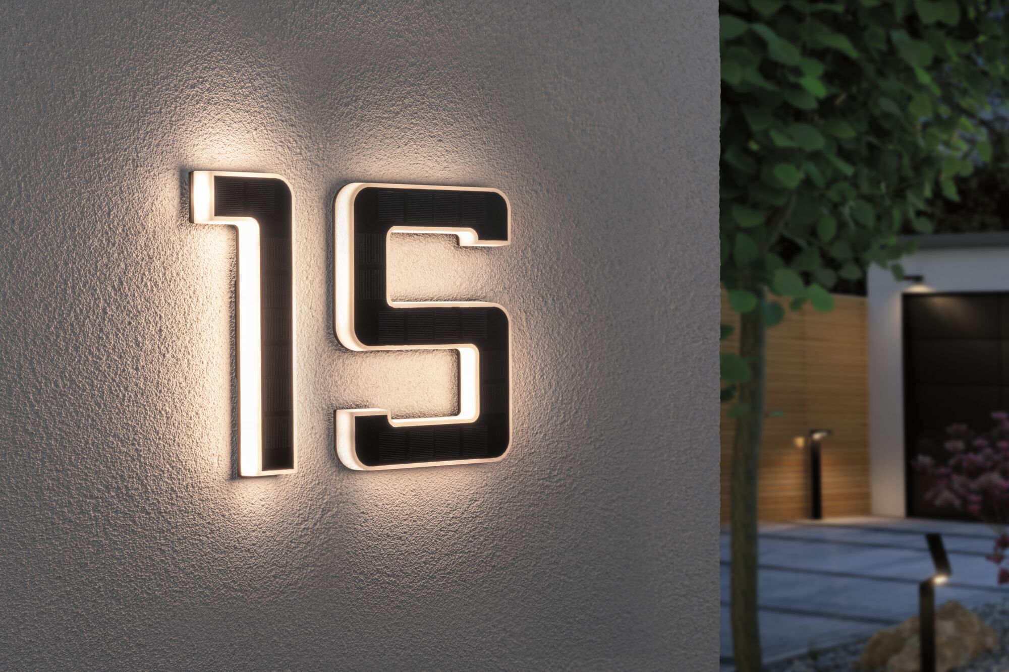 Huisnummer 15 met zwarte zonne-LED-verlichting op witte buitenmuur