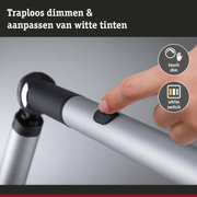 Vinger drukt zwarte dimknop op zilveren aluminium statief voor LED-verlichting