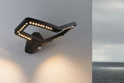 Moderne schwarze LED-Außenwandleuchte mit Bewegungsmelder und warmweißem Licht für Hausfassaden.