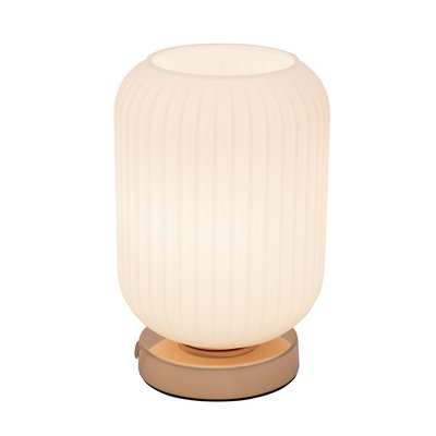 Table lamp with ribbed white glass and gold metal base for ambient lighting in living spaces