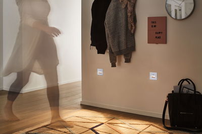 White LED night lights illuminated in hallway with wooden floor, rug and coat rack for safe navigation