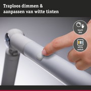 Vinger drukt witte dimmerknop op moderne LED-trapverlichting voor traploos dimmen