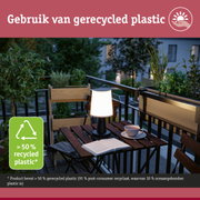 Zwarte buitenlamp voor op tafel gemaakt van meer dan 50% gerecycled plastic op balkon met planten