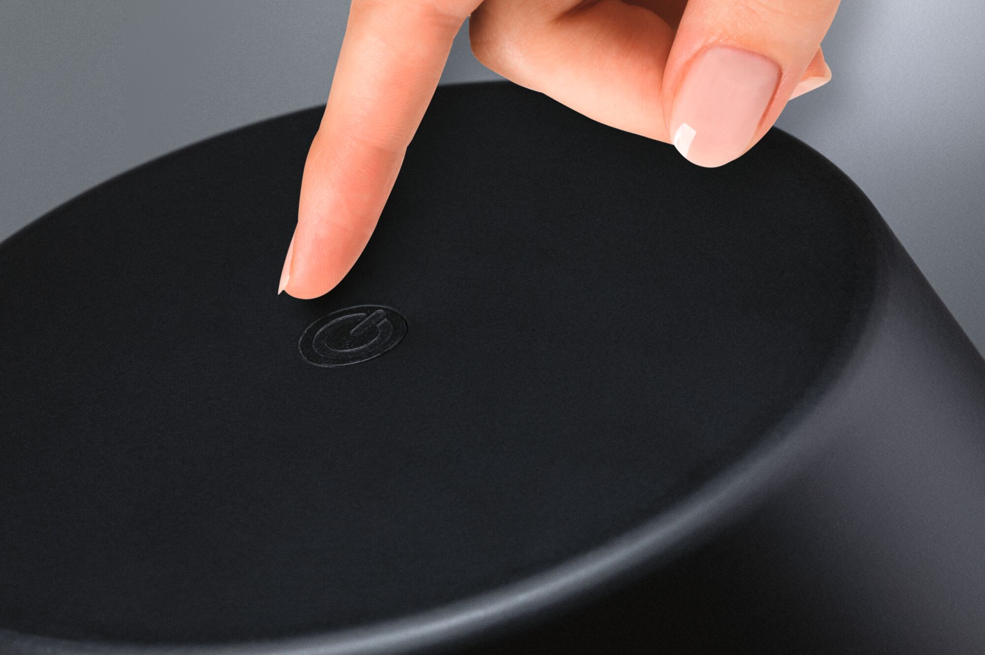 Finger berührt schwarzen Touch-Schalter auf rundem Gerät aus Kunststoff für einfache Bedienung