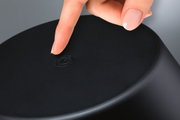 Finger berührt schwarzen Touch-Schalter auf rundem Gerät aus Kunststoff für einfache Bedienung