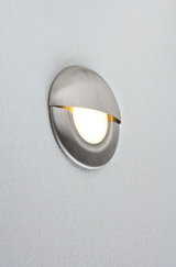Round LED wall light in brushed stainless steel with warm white light for modern interiors