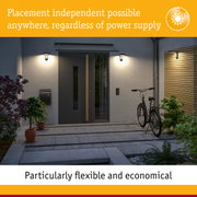 Modern black outdoor wall lights illuminating entrance with door and bicycle at night