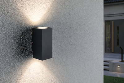 Schwarze Aluminium-Wandleuchte mit Up- und Downlight an grauer Außenwand für moderne Außenbeleuchtung