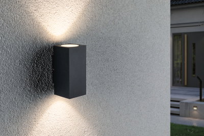 Schwarze Aluminium-Wandleuchte mit Up- und Downlight an grauer Außenwand für moderne Außenbeleuchtung