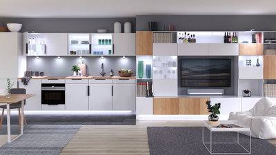 Cuisine blanche moderne avec plan de travail en bois et éclairage LED intégré dans un salon ouvert avec TV.