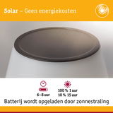 Witte solar lamp met zwart zonnepaneel bovenop, batterij wordt opgeladen door zonnestraling