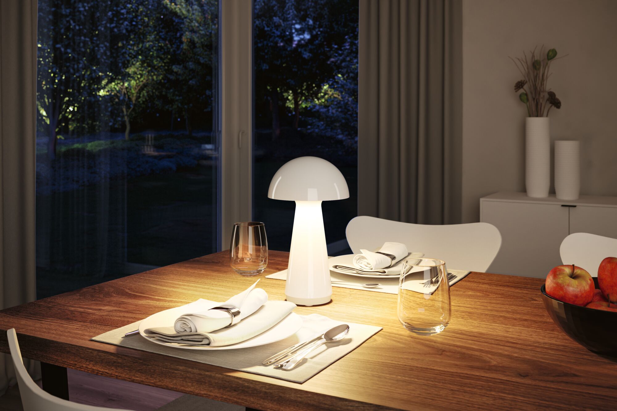 Modern white plastic table lamp on wooden table with set dining place and apples bowl.