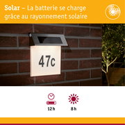 Éclairage solaire pour numéro de maison avec toit en acier inoxydable et panneau lumineux blanc sur mur en brique rouge