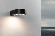 Schwarze LED-Außenwandleuchte aus Metall mit rundem Design und warmweißem Licht für Hausfassaden.