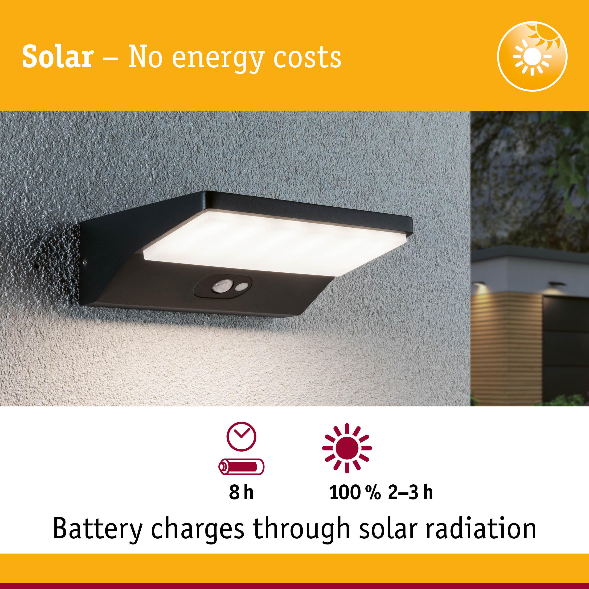 Black solar wall light with motion sensor on grey wall, energy-saving outdoor lighting solution