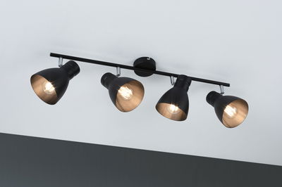 Plafonnier en métal noir avec quatre spots réglables pour un éclairage moderne.