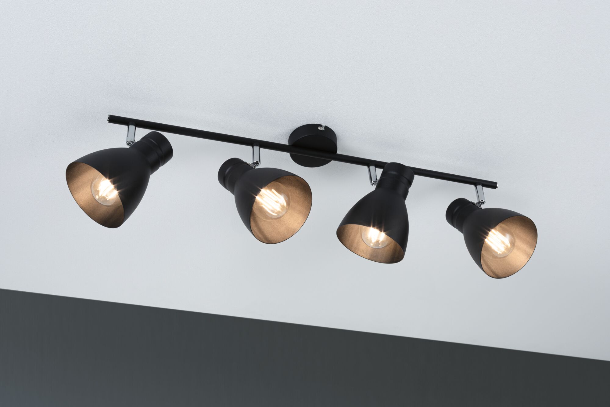 Plafonnier en métal noir avec quatre spots réglables pour un éclairage moderne.