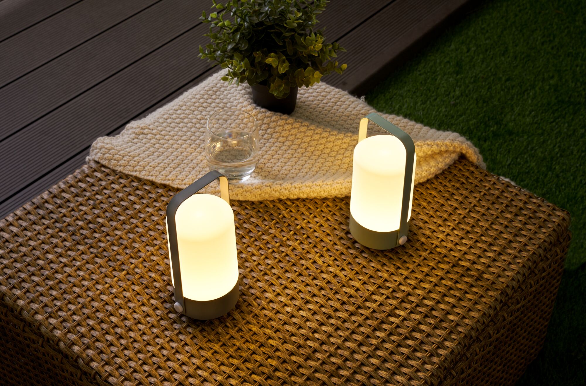 Deux lampes de table LED portables avec lumière blanche chaude sur table de jardin en plastique tressé.