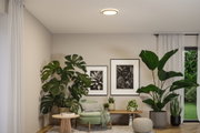 Plafonnier rond avec anneau LED blanc chaud dans un salon moderne avec plantes vertes et meubles en bois.