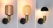 Drei moderne Wandlampen mit schwarzem und goldfarbenem Metall, verschiedene Lampenschirme und warmes Licht.