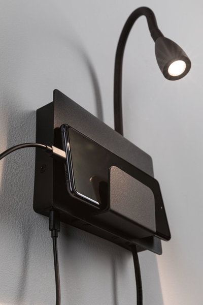 Black wall lamp with flexible arm and metal phone holder, perfect for bedroom lighting and charging station.