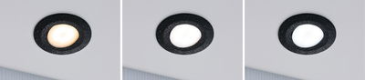 Drie zwarte LED-inbouwspots met verschillende lichtkleuren aan witte plafond, moderne binnenverlichting