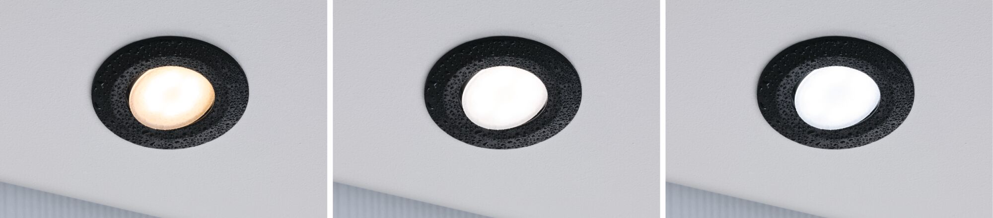 Drei schwarze LED-Einbaustrahler mit unterschiedlicher Lichtfarbe an weißer Decke, moderne Innenbeleuchtung