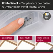 Main réglant la température de couleur sur un plafonnier LED blanc avec cadre en bois